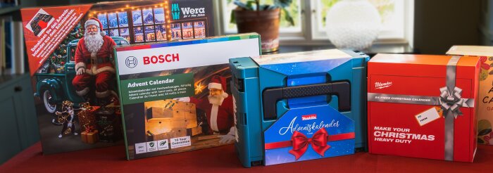 Fyra olika verktygs-julkalendrar från Wera, Bosch, Makita och Milwaukee står på ett bord.