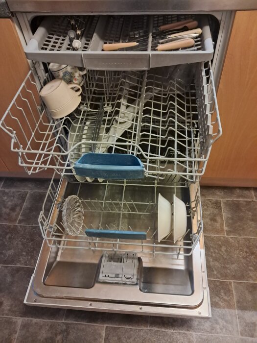 Öppen diskmaskin av märket Bosch Supersilence med porslin och bestick i.