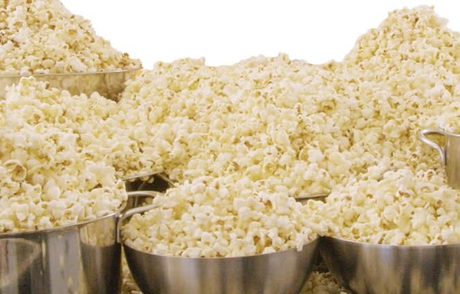 Massor av popcorn i flera stora metallskålar, redo för en lång väntan.