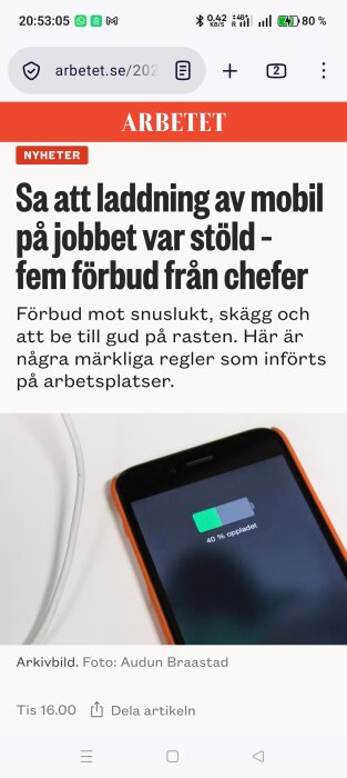 Smartphone med laddningskabel visar 40% batterinivå, relaterad artikel om laddning som stöld på arbetsplatsen.