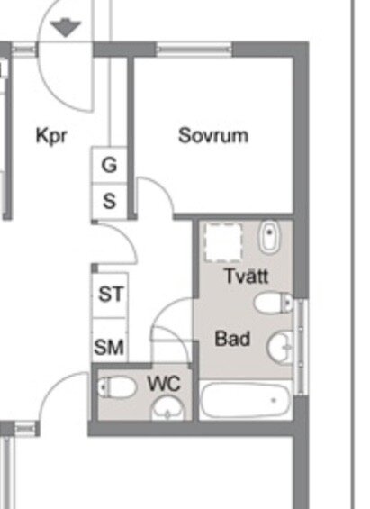 Planlösning som visar ett badrum med tvättstuga och två toaletter, samt anslutande sovrum. Badrummet gränsar till ett rum märkt WC.