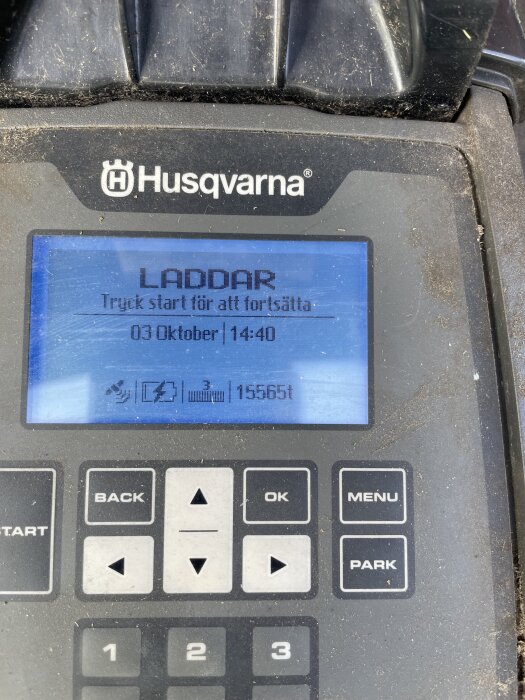 Husqvarna robotgräsklippare display visar "LADDAR" och information om starttid, datum och driftstimmar.