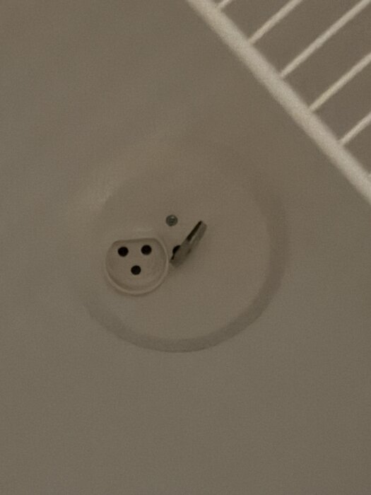 Rökdetektor i taket med en närliggande ventilationsöppning synlig.