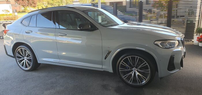 Grå BMW parkerad i en uppfart, nyligen behandlad med keramisk lackförsegling.