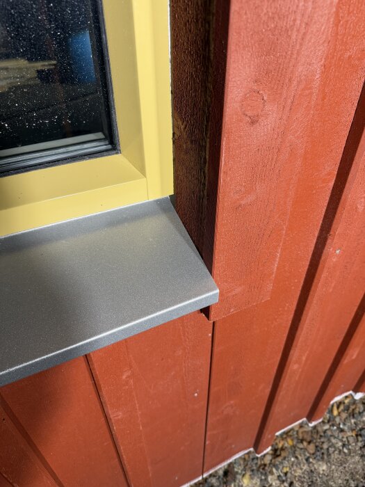 Fönsterbleck och lockläktspanel i röd träfasad med gul fönsterram; spillbit av plåt visas utan uppvik.