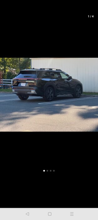 Svart SUV parkerad framför en vit byggnad, diskussion om bilens utseende och styling.