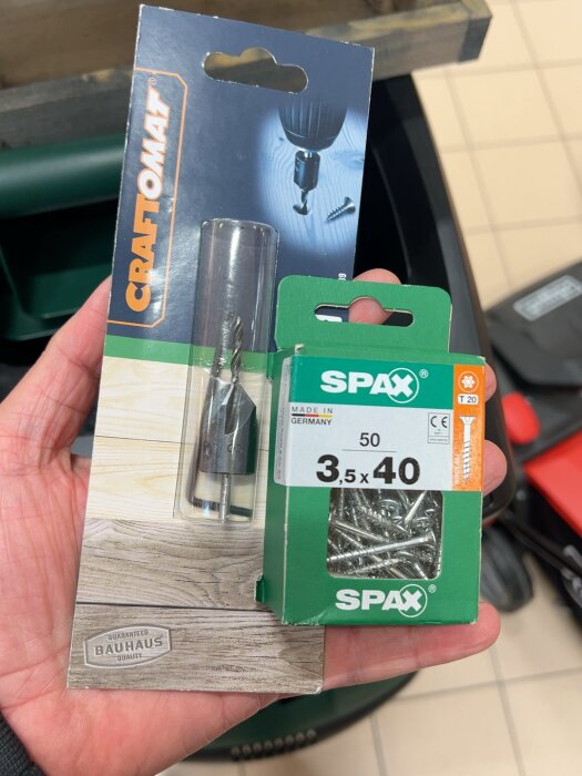 Förpackning med 3,5 × 40 mm SPAX-träskruvar och en CRAFTOMAT-borrhållare, hålls i en hand, används för listinfästning.