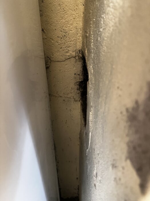 Öppning i murstock där oljepanna har kopplats, visar en hålrum i väggen.