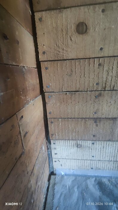 Sned innervägg med träpanel i kök, där plywood diskuterats som ny interiörbeklädnad.