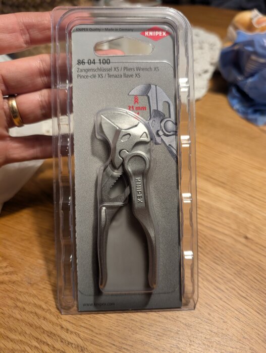 Förpackning med Knipex kombinationstång XS, detaljrik bild av verktyg i plastförpackning på träbord.