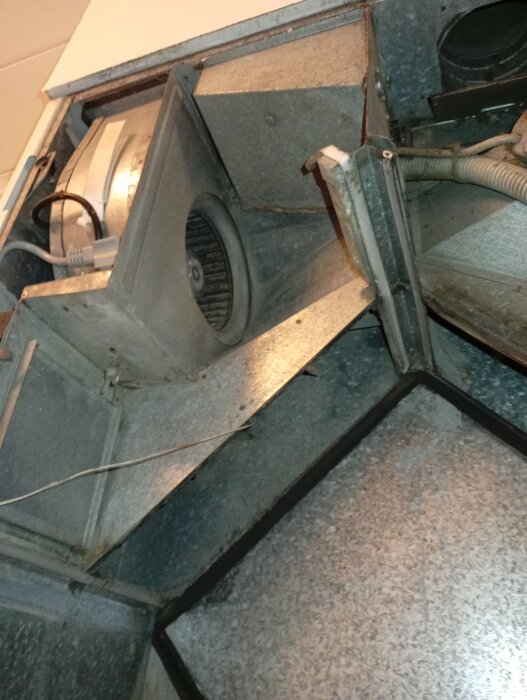 Ventilsystem med öppet spjäll inuti, synlig sladd och mekanisk komponent, relaterat till diskussion om trådkontroll och luckfunktion.