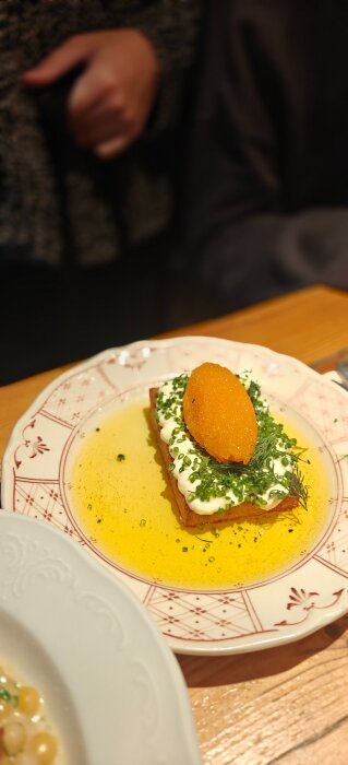 En tallrik med smörstekt toast toppad med crème fraîche, örter och en klick rom.