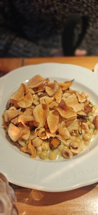 Tallrik med rotfruktschips, svamp och bönor i gräddsås på Mellqvist.