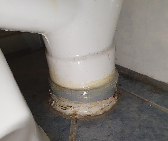 Toalettstol installerad direkt i avloppsrör, med tätning runt basen.