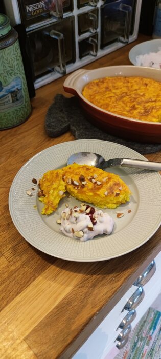 Risgrynspudding med saffran och lingonfluff serverad på en tallrik med hackade nötter på toppen.