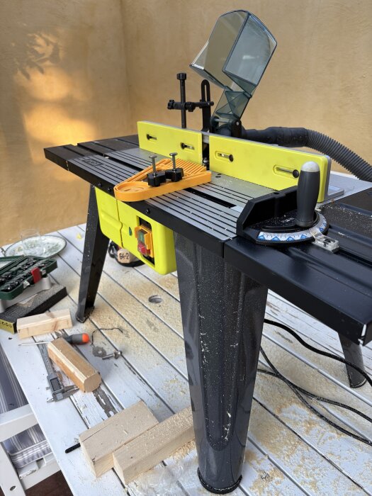 Ryobi fräsbord på träbord med verktyg och träbitar, används för att tillverka spröjs till fönsterbågar från 1932.