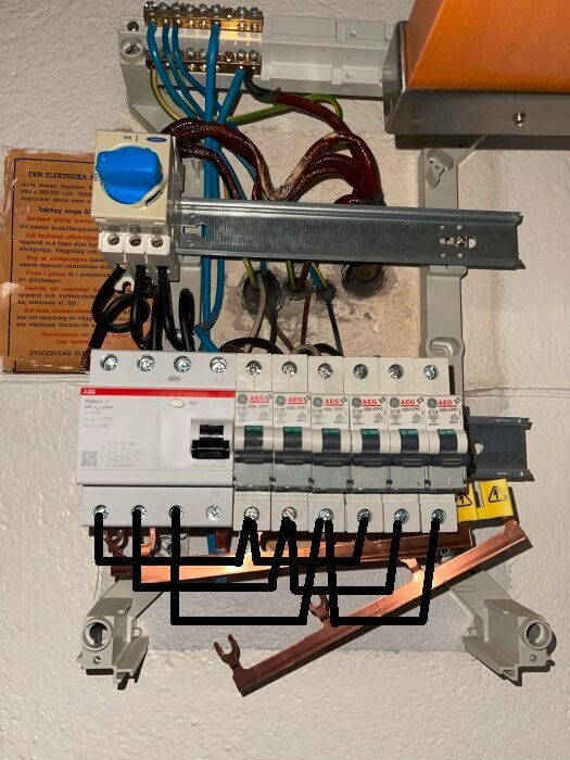 Elcentral med flera säkringar, kablar och en strömbrytare monterad på en vägg, del av ett elektriskt system förfördelning.