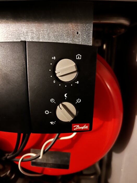 Termostat från Danfoss med två justeringsvred, monterad på en fjärrvärmecentral.