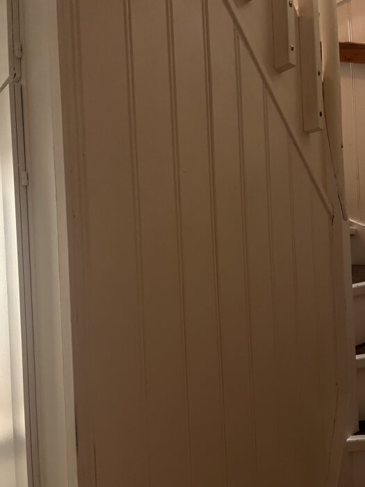 Vägg med träpanel i en trappa, personen söker råd för att få den slät.