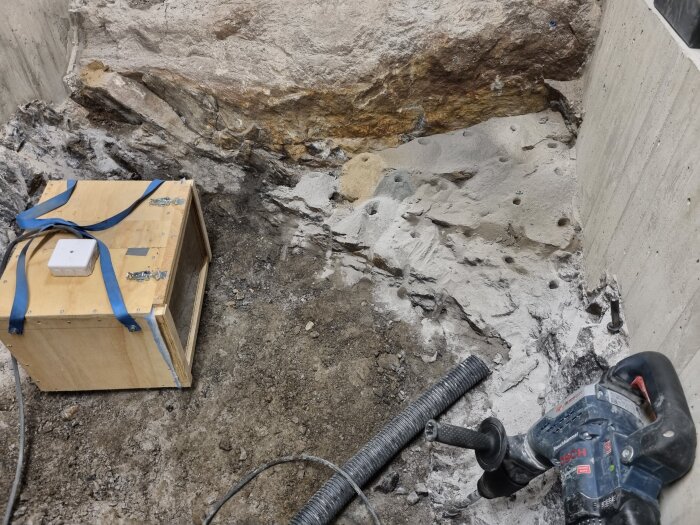 Borrprojekt med flera hål i betongvägg, luftrenare Mk2 används som punktutsug bredvid en trasig dammsugare och borrmaskin.