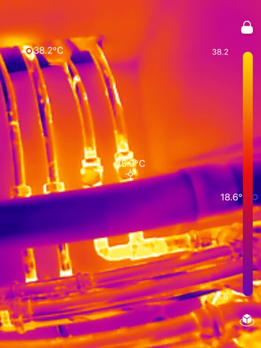 Värmekamera visar flera rör med olika temperaturer. Temperaturen syns som vita och orangea toner; fokus på 25,9°C och 38,2°C på specifika delar.