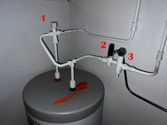 Installationsbild av vattenvärmare med rörsystem. Positioner markerade: 1 blandningsventil, 2 säkerhetsventil, 3 misstänkt vakuumventil. Röd borste synlig.