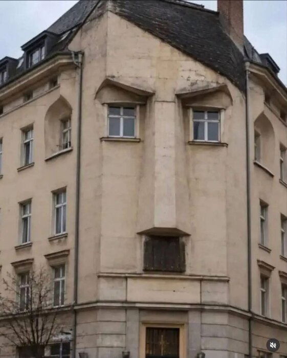 Byggnad vars fasad liknar ett ansikte med fönster som ögon och balkong som mun.