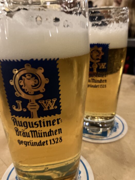 Två glas öl med etiketten "Augustiner Bräu München 1328" på ett bord.