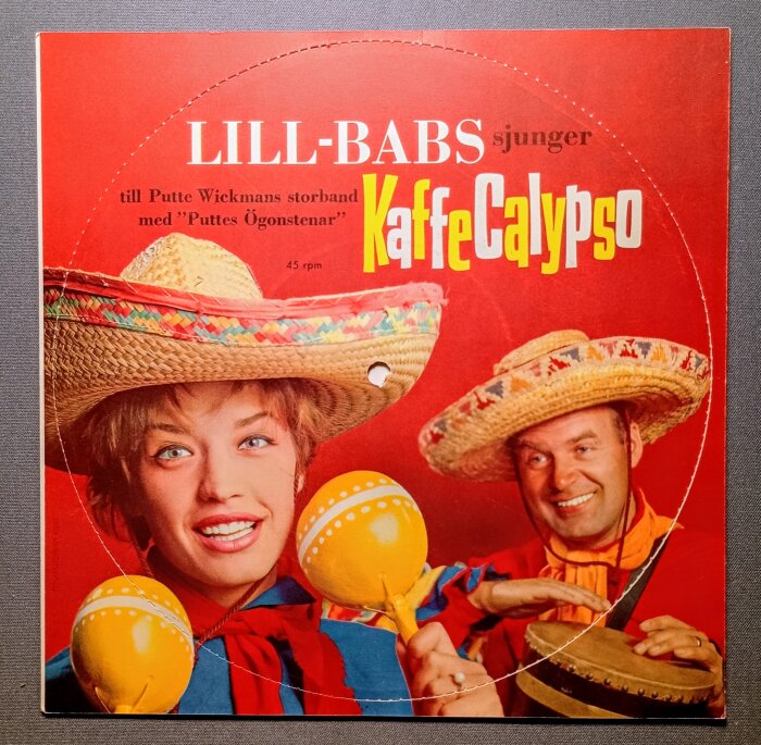 Omslaget till en flexiskiva från 1961 med Lill-Babs som sjunger Kaffe Calypso med Putte Wickmans storband, färgglada sombreros och musikinstrument.