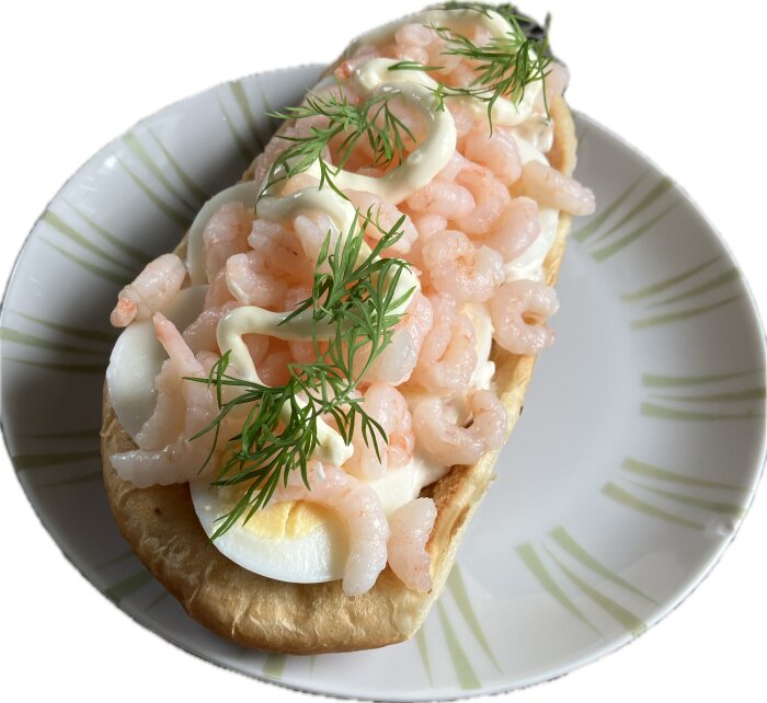 Räksmörgås med räkor, ägg, majonnäs och dill på ett fat.