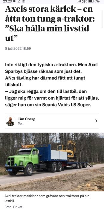 Grön lastbil med ett långt släp transporterar en gul grävmaskin på en landsväg kantad av träd.