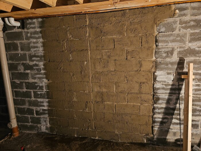 Löst applicerat c-putsbruk på betonghålstenar med ojämn täckning, visar början på putsarbete med kalkborste.