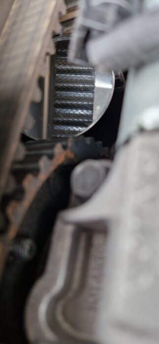 Närbild av kamrem och kugghjul i en Volvo V70:s motor, inspektion för slitage efter 12 års användning.