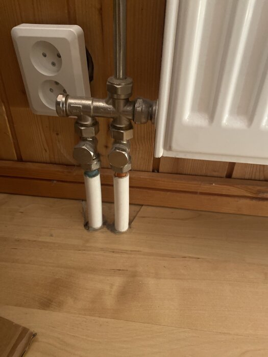 Ventil och röranslutning vid radiator, eluttag till vänster.
