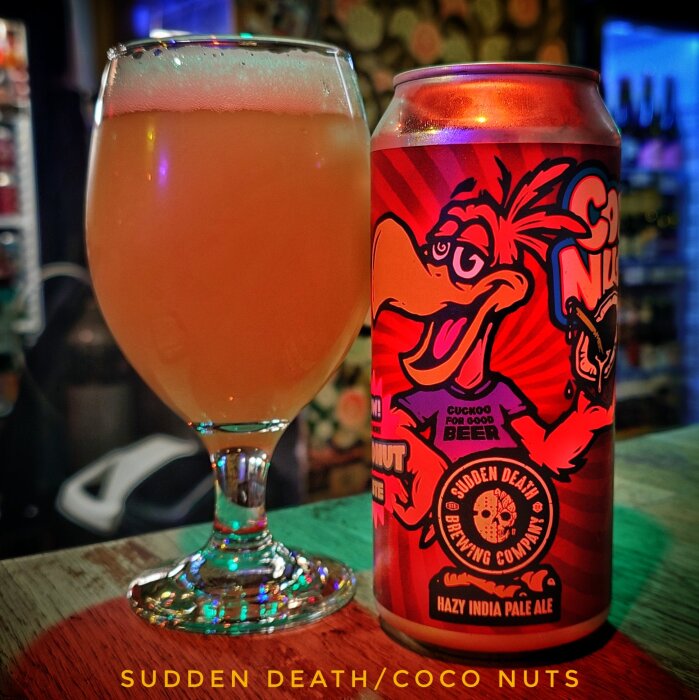 Glas med hazy IPA och burk med färgglad etikett från Sudden Death Brewing, med motiv av tecknad fågel och texten "Coco Nuts".