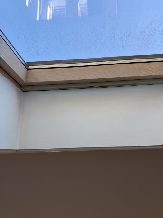 Takfönster med träkarm och kondensfläckar på glaset, relaterat till fuktproblem vid minusgrader.