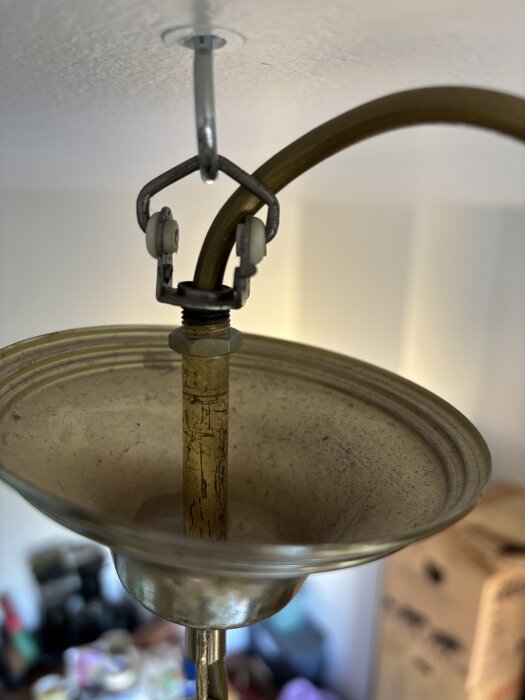 Taklampa i metall monterad i taket med synlig krok och sladd som inte är inkopplad, användning av grön/gul kabel saknas.