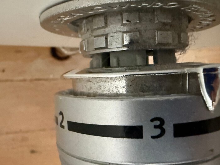 Silverfärgat Jaga-element termostathuvud med skala 1-3, förkromad detalj och fyrkantiga hål; gråa plastklor synliga mellan delar.