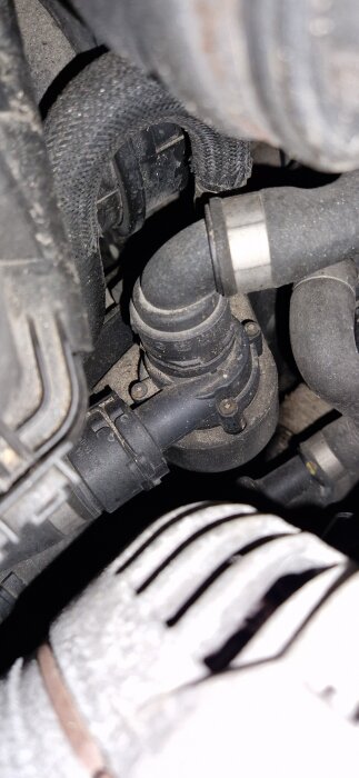 Kabelanslutningar och rör nära motorn i en BMW 525i-05, eventuellt relaterade till den elektriska hjälppumpen.