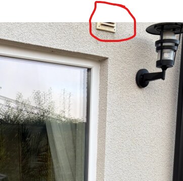 Fasad med fönster, lampa och markerat friskluftsintag.