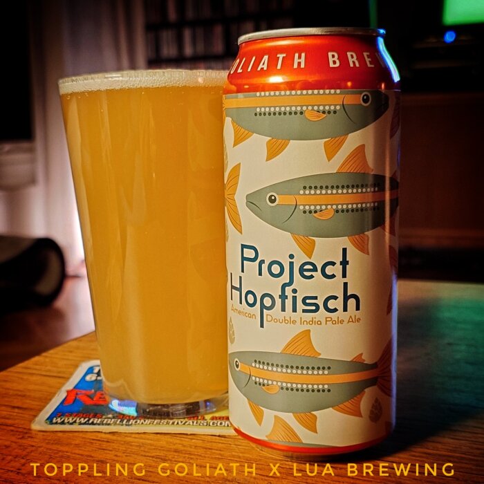 En burk "Project Hopfisch" Double India Pale Ale och ett glas fyllt med ljus bärnstensfärgad öl på ett bord.