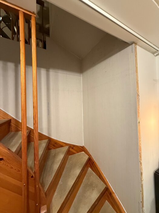 Förråd byggt ovanför en trätrappa med gipsade väggar, där mosaik dolts och spackling påbörjats.