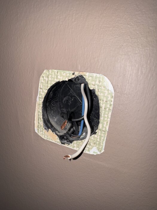 Öppen väggdosa med tre synliga kopparledare, inklusive en vit och en svart ledare, för installation av dimmer.