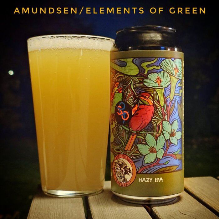 Burk och glas med Hazy IPA från Amundsen Bryggeri, färgstarkt illustrerad etikett, placerade på ett bord i natten.