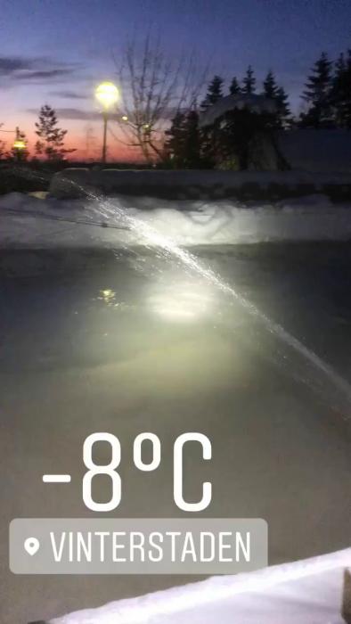 En person sopar bort snö i vinterstaden vid -8°C, en vanlig hushållssyssla under de kalla månaderna.