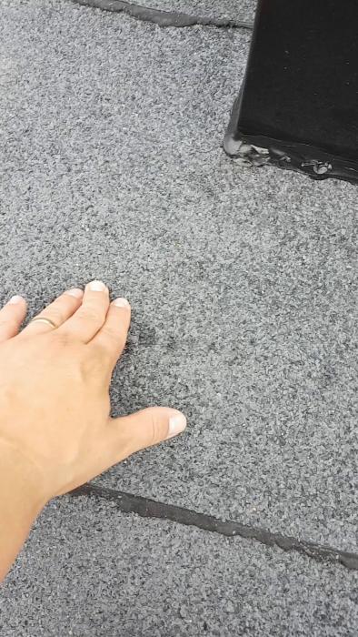 Efter att ha anlitat ett företag för att byta takpapp upptäcker husägaren läckage vid skarven mellan huv och papp. Företaget lagar läckan, men vattenansamling och fukt i köket kvarstår. Video visar del av taket där problemet uppstått.