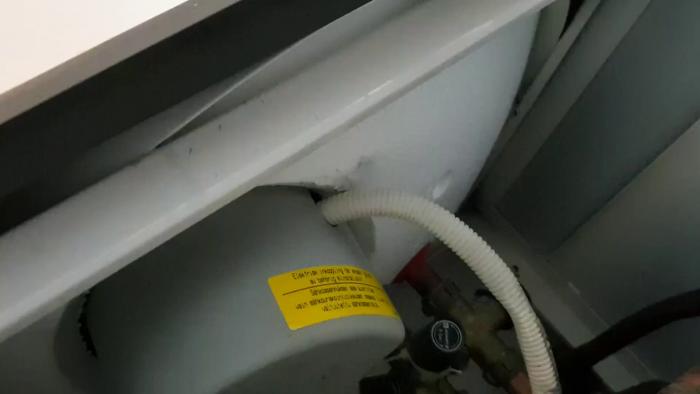 Video som visar läckage från en gammal varmvattenberedare i ett radhus från 1975. Användaren söker hjälp för att förstå varför behållaren läcker vatten uppifrån.