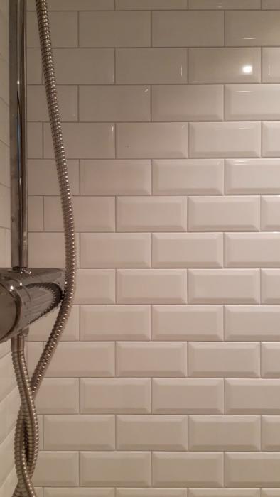 Kunden upplever problem med en takduschblandare från IKEA som ger vika när den används. Diskussion kring korrekt höjd och installation i ett nyrenoverat källarbadrum med låg takhöjd.