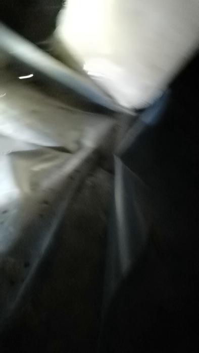 Amatörer undersöker fukt i torpargrunden med pannlampa. Filmen visar fuktiga områden och vattendroppar under hallen, samt diskuterar möjliga lösningar och behovet av åtgärder.