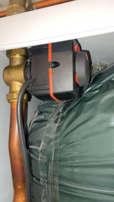 Det är en närbild på en del av en svart och orange mätare eller vred med en otydlig grön bakgrund.